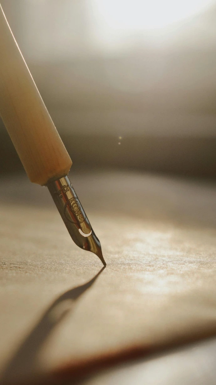 Stylo écrivant sur une feuille, illustrant un espace de réflexion et d’écriture autour de la thérapie et des passages de vie.